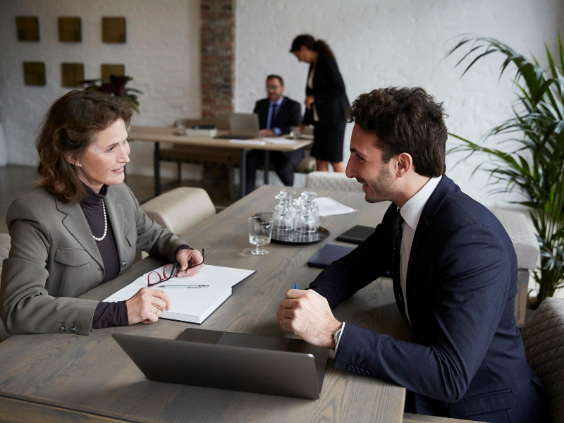 advisor consulting by laptop with businessman during meeting at office