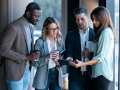 Diverse group looking at tablet outside office
