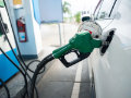 Handle of gas pump hanging off the side of a car