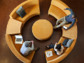 overhead view of casually dressed business people sittng on curved modern sofas