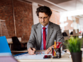 Man in suit with tie at his desk working on a project