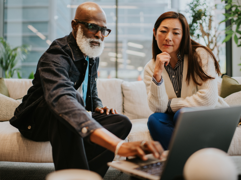 diverse businessman and business woman on a sofa in a office having a casual business meeting