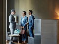 businessmen and businesswoman discussing while standing in lobby