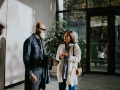 diverse multi-generational man and woman talking in modern building lobby