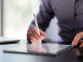 hands extended on tablet signing tablet electronically
