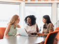 diverse group of seated young professionals meeting in front of laptop