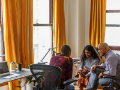 diverse multi-generational male and female business colleagues meeting with tablet sitting in office