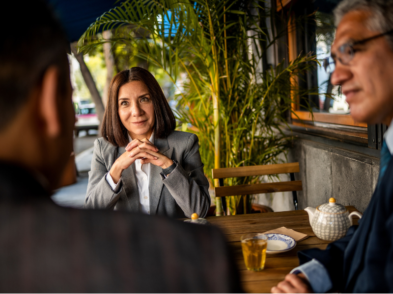 three business people sitting in cafe and talking