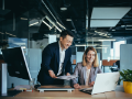 two employees in an office discussing and consulting
