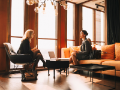 diverse young professionals talking while sitting by window in office