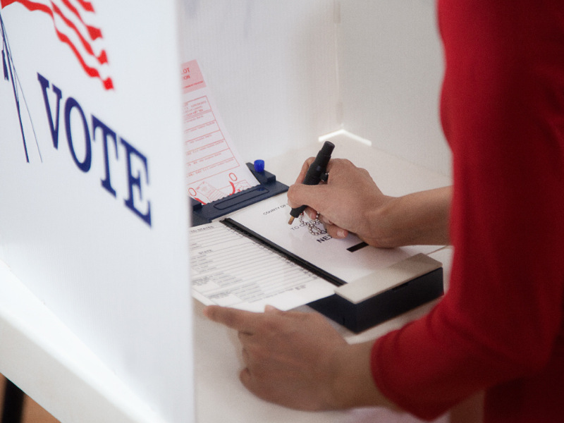 Voter in polling place checking a ballot