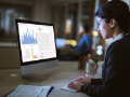businesswoman examining business charts on desktop PC in the office.