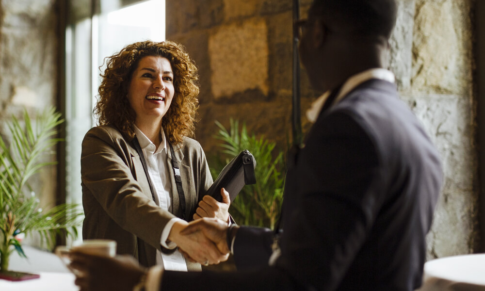 standing financial advisor with client in bank lobby