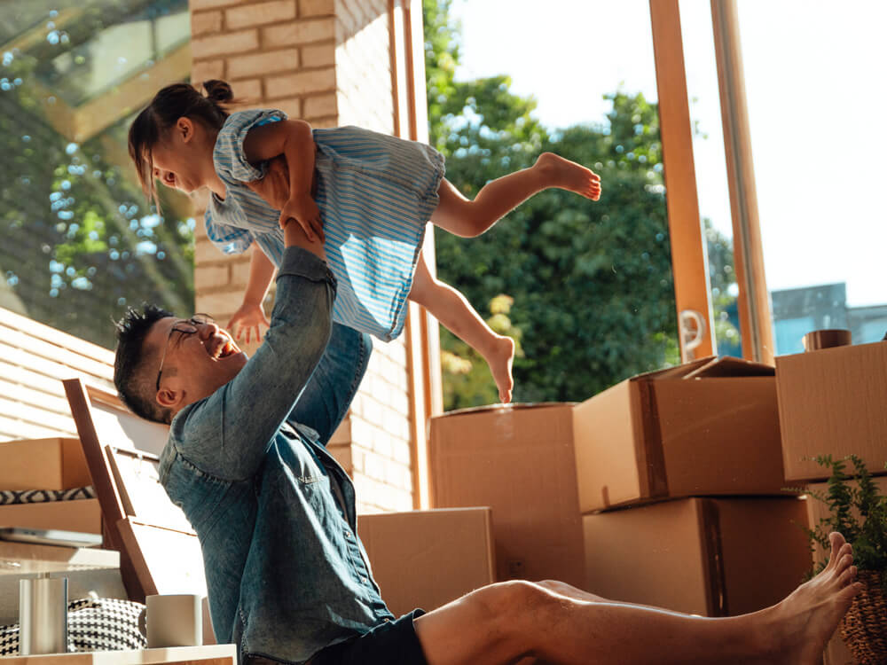 young father in new home, lifting daughter up in the air