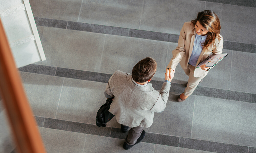 overhead view of financial advisor talking to a recruiter in an office lobby