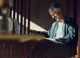 Man at home on laptop laughing