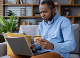 concerned man on laptop with credit card in hand