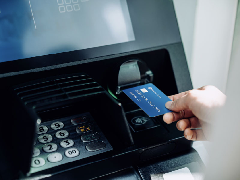 closely cropped, hand inserting credit card into atm slot