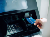 closely cropped, hand inserting credit card into atm slot