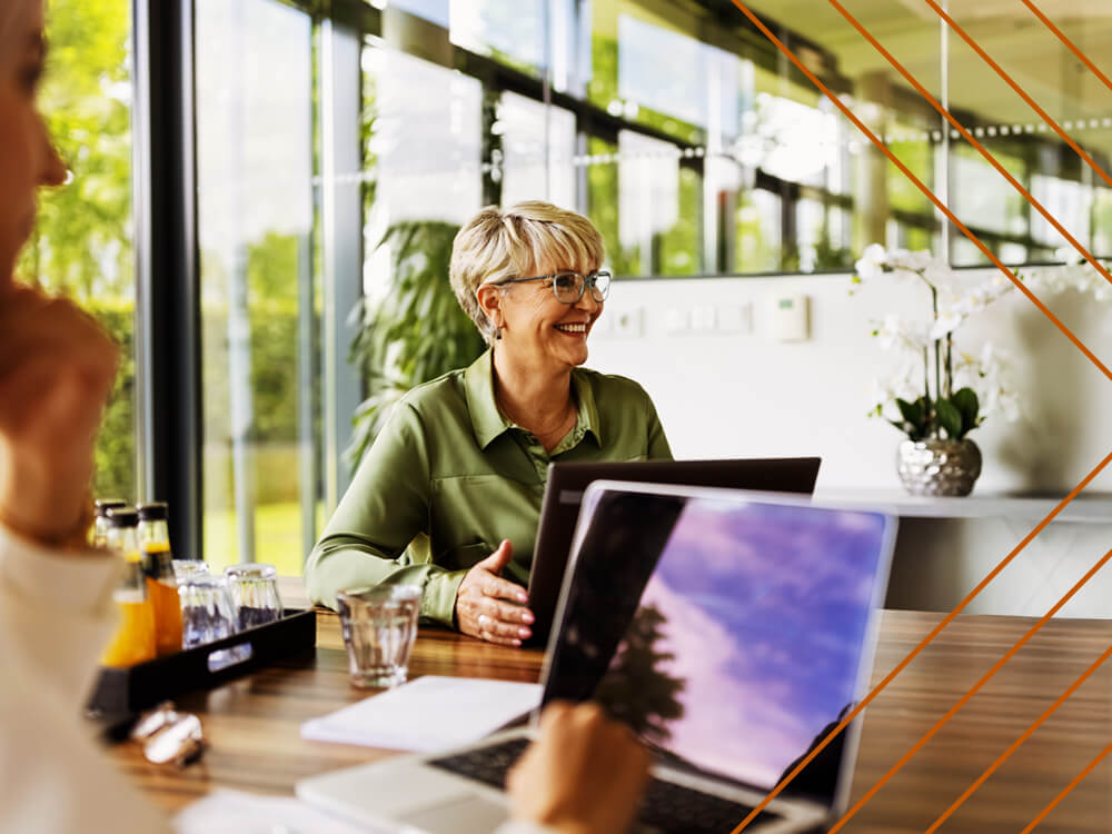 Smiling businesswoman meeting in a bright, windowed conference room