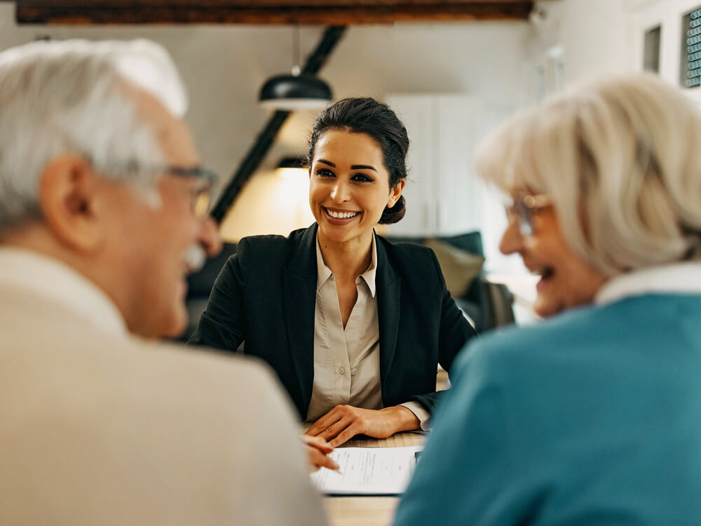 young businesswoman seated with blurred older couple in foreground