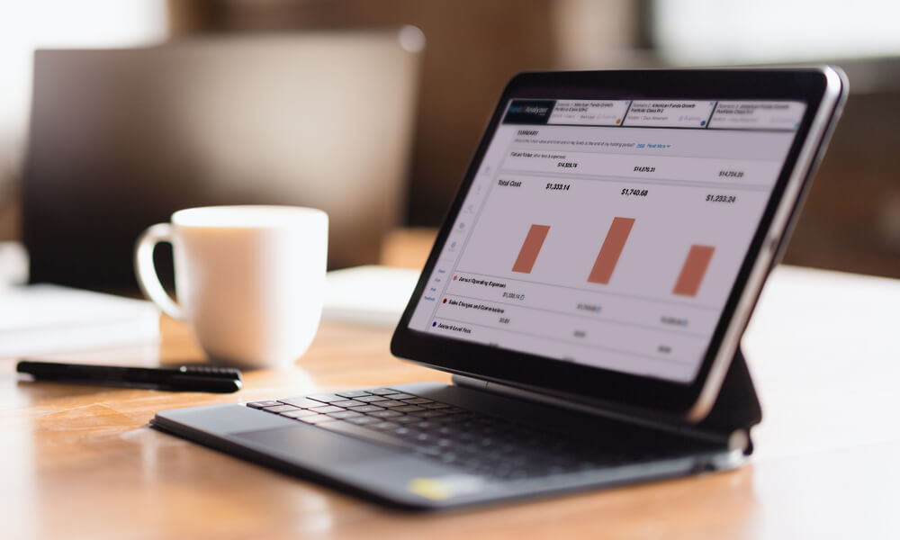 open laptop with charts on screen on office desk