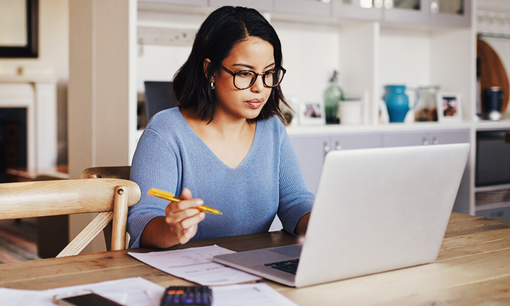 young business woman sitting at a laptop on a table in office kitchen