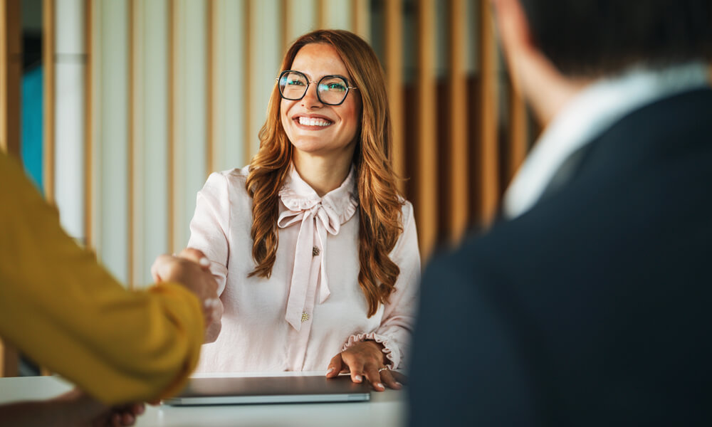 seated young business woman greeting couple