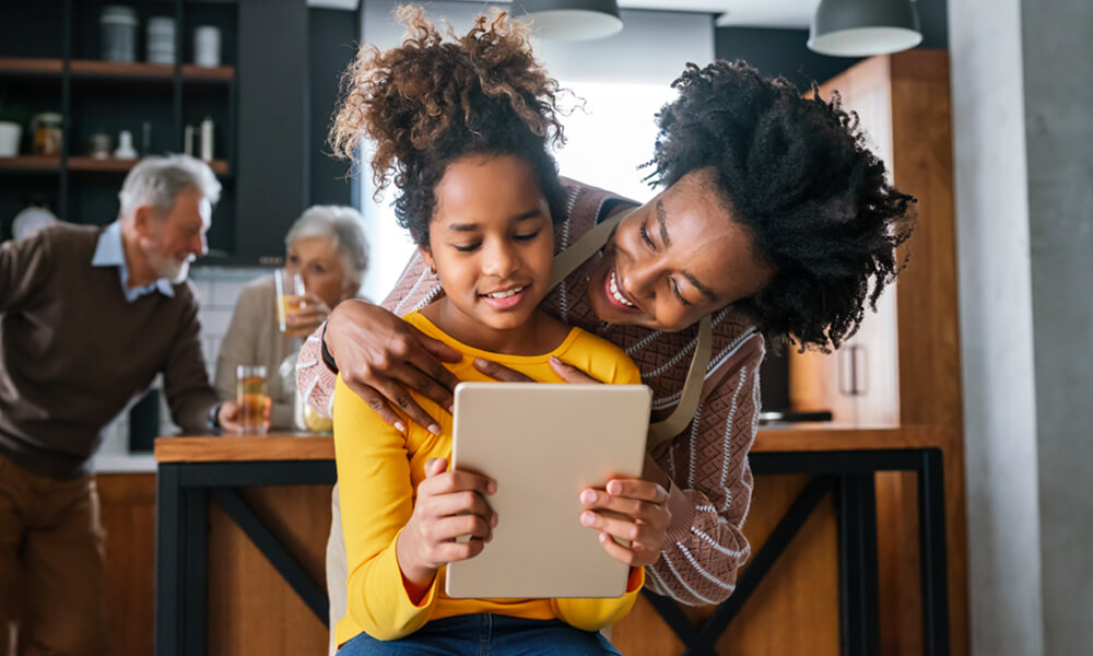 young mother with pre-teen school-aged child looking at tablet 