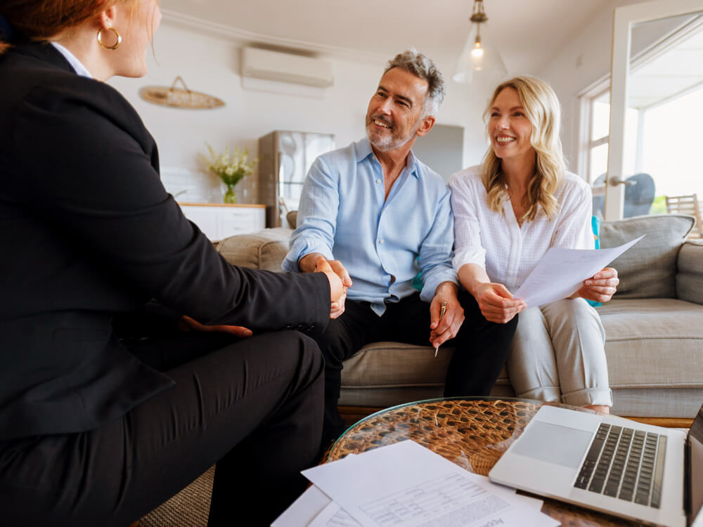 couple sitting on couch talking with financial advisor