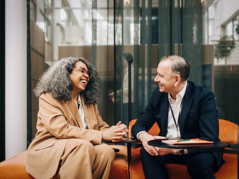 two people talking and laughing in a lobby