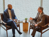 seated financial advisors talking in front of office building window