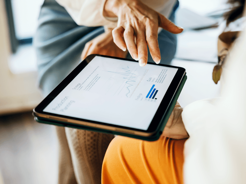 Cropped view of financial advisor showing financial information to client on an Ipad.