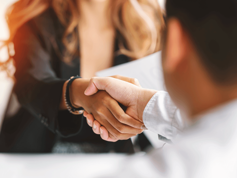 Cropped view of financial advisor shaking hands with client.