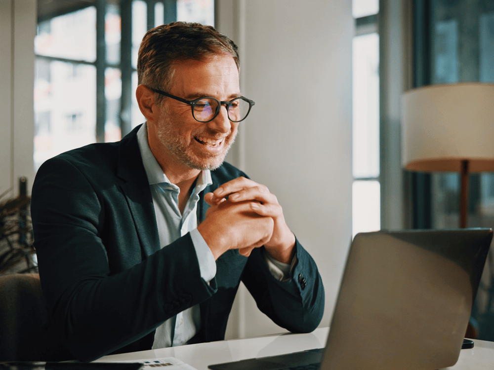 Smiling middle-age man looking at his financial investments performance.