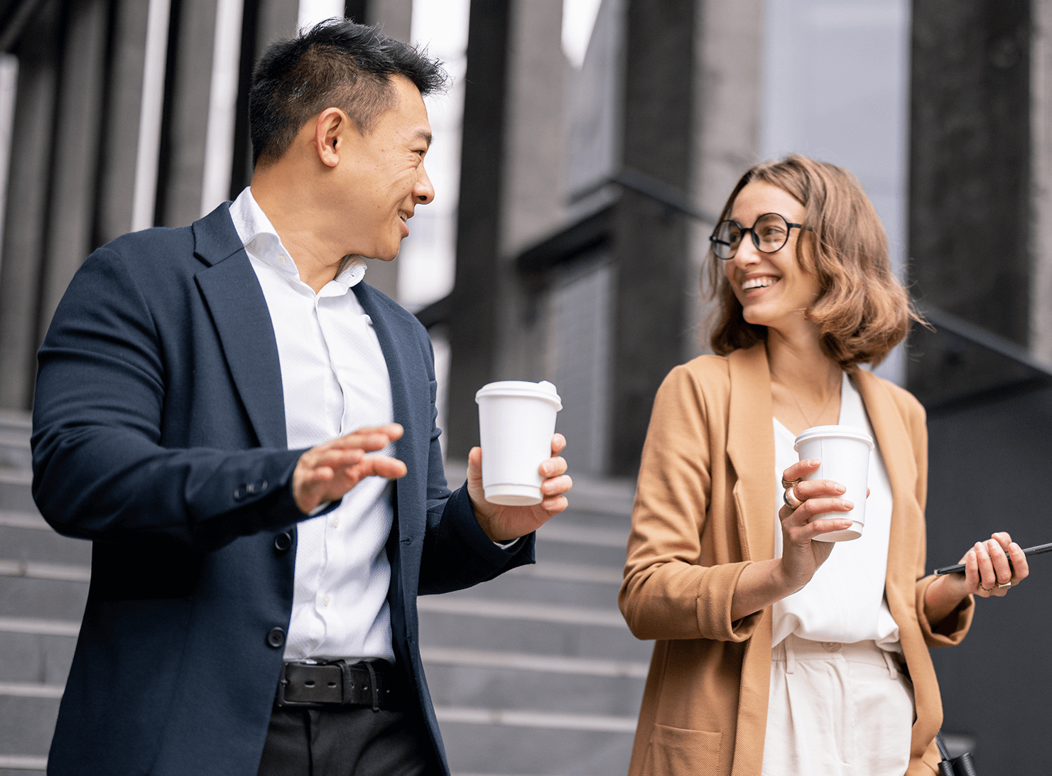 male and female colleagues walking down outside stairs talking