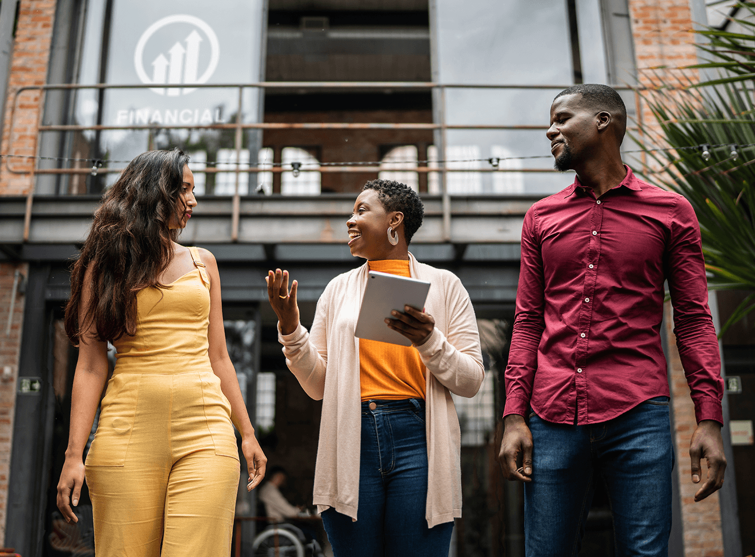 diverse young man and woman walking outside with one with electronic tablet in hand