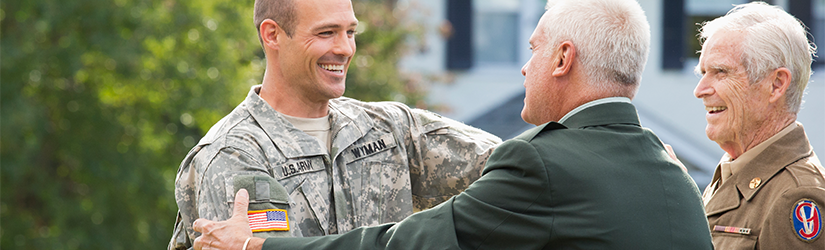 3 military men greeting each other arms extended