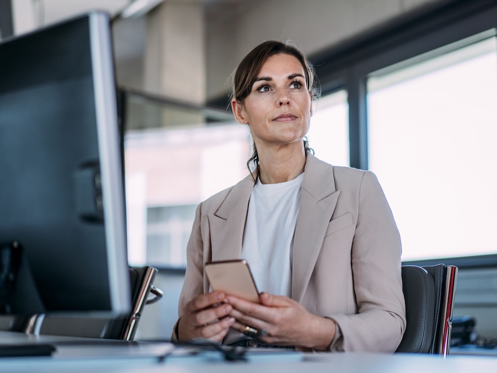 Seated financial advisor with phone in hand.