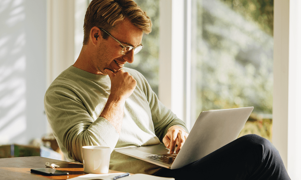 Young investor managing finances on laptop at home