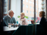 older couple seated at long office table talking with financial advisor