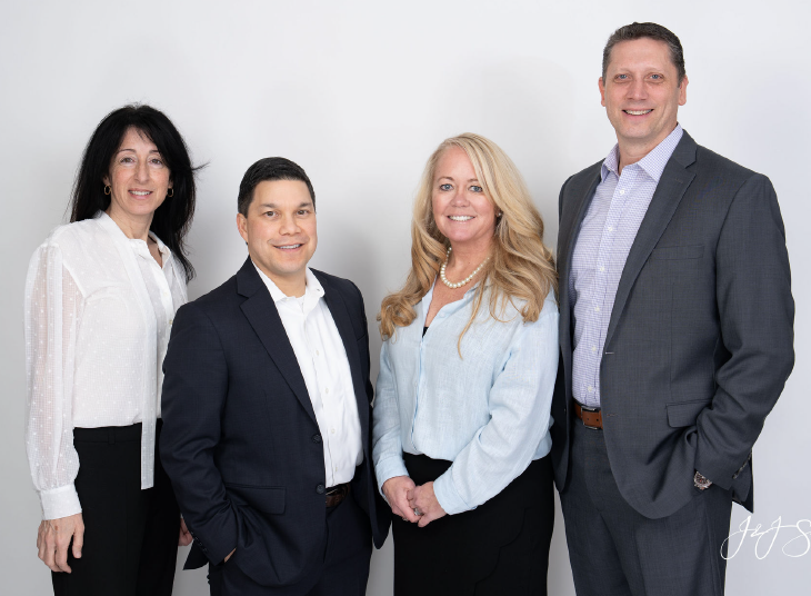 Four business professionals in front of a white background