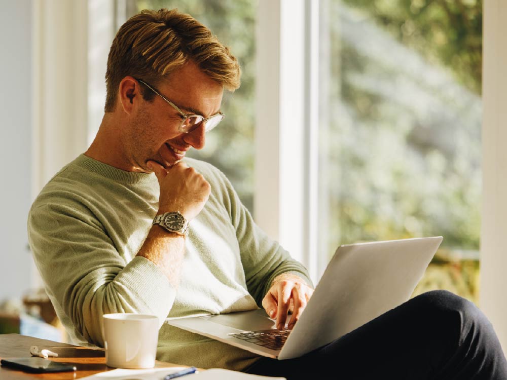 Market Education - Man working on laptop Midyear Outlook 
