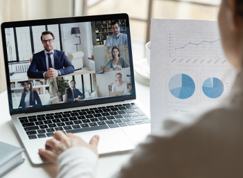 Virtual meeting via laptop, women and men on screen, hand on keyboard image