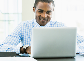 African American man seated at laptop image