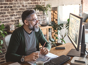 Caucasian man at sitting in front of monitor at work image