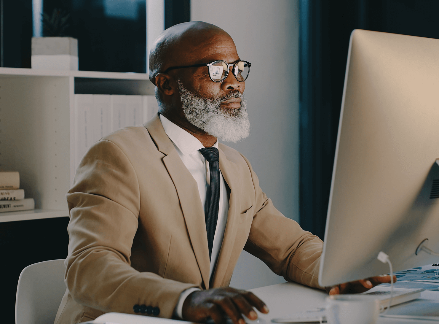 diverse older businessman seated in front of large computer screen stock image