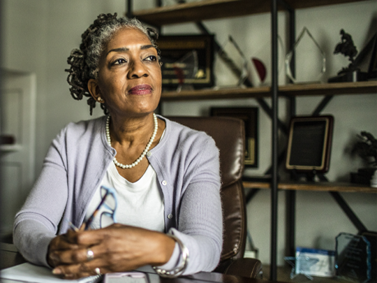 older african american woman sitting at desk in office