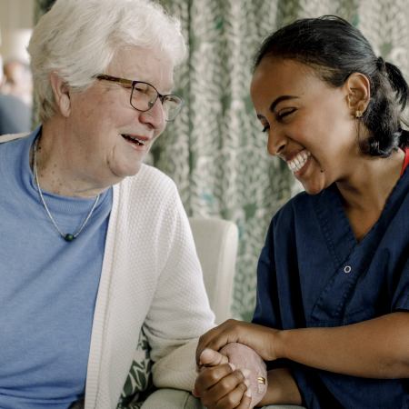 smiling young african american caregiver and caucasian older woman holding hands image